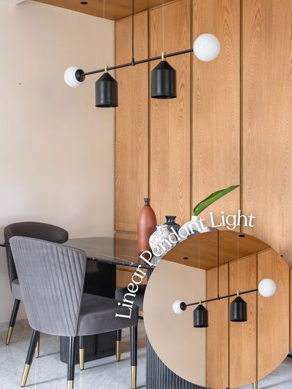 A linear pendant light with black and gold accents hangs over this dining table. The modern, geometric design of the fixture adds a sophisticated touch and provides focused lighting for intimate meals.