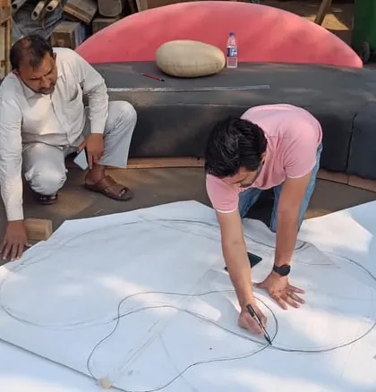 Every custom piece starts with an idea and a sketch. Here I am on-site, drawing out the full-scale template for a uniquely shaped center table. This hands-on process ensures the final product is exactly as envisioned.