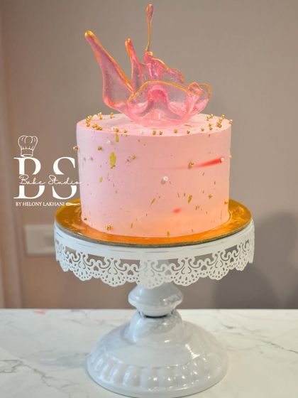A finished pink whipped cream cake with an elegant isomalt sculpture, demonstrating the beautiful and modern techniques taught in my class.