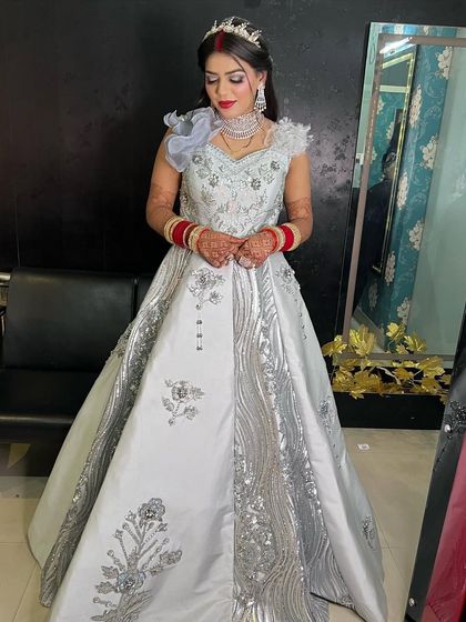A beautiful reception bride in a silver-grey gown. The makeup is glamorous, with a bold red lip and shimmery eyes.