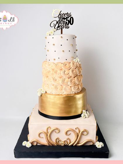 Cheers to 50 years! A magnificent four-tiered anniversary cake in gold and blush tones, featuring a rosette-covered tier and ornate baroque details.