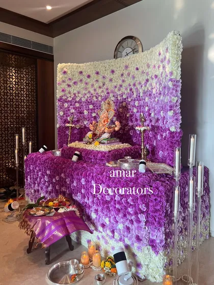 My ombré floral walls are a huge hit for Ganesh Chaturthi. This mandap showcases a beautiful gradient of purple and white flowers, creating a dense, luxurious backdrop for Bappa. The design is complemented by modern candle stands for a soft glow.
