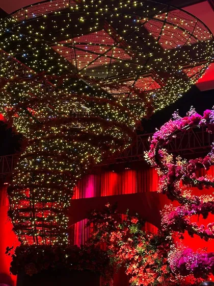 A close-up of the fairy-light-wrapped floral tornado installation, showcasing the immense detail and scale of this signature statement piece.