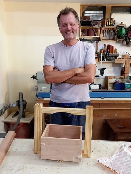 Chris, a traveler from abroad, standing proudly with the wine caddy he built. He wanted to get in touch with his creative side while visiting, and this was the perfect project.