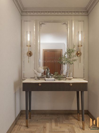 The foyer in this neo-classical home sets a tone of refined elegance with a fluted console table, ornate mirror, and classic wall sconces.