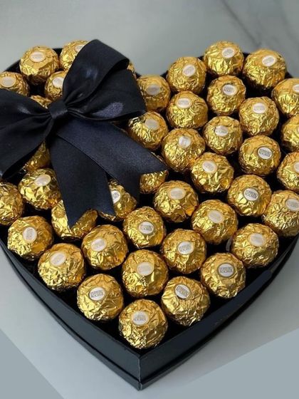 For the purist, this heart-shaped box is filled to the brim with golden Ferrero Rocher chocolates and finished with a simple, elegant black bow. It's pure, unadulterated chocolate bliss.