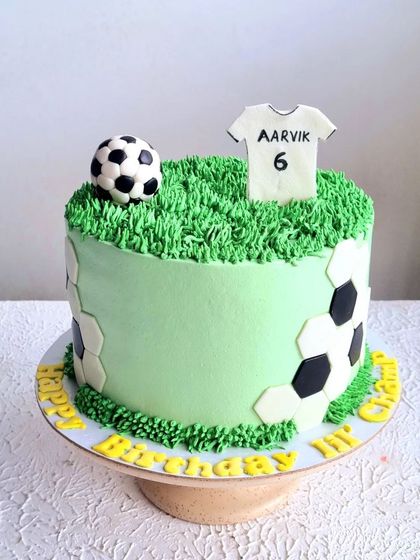 A football-themed cake with a buttercream grass pitch and a fondant jersey. This is a great way to personalize a cake for a sports fan.