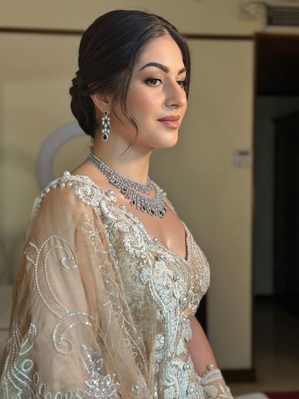 A side view of Oezlem's sangeet look. The elegant updo is visible, along with the soft glow on her skin, creating a polished and sophisticated silhouette.