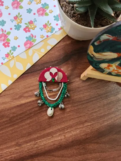 A selection of my Navratri-themed hair brooches and pins. These feature colorful fabric, mirrors, cowrie shells, and even a small bird charm, perfect for adorning a festive bun.