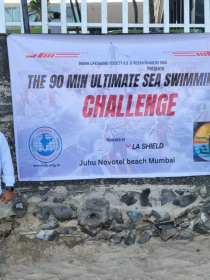 The official banner for "The 90 Min Ultimate Sea Swimming Challenge" presented by the Indian Lifesaving Society and Ocean Rangers OWS at Juhu Novotel beach.