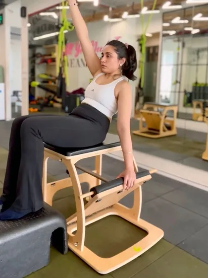 It's not just about the reformer. We use a variety of equipment like the Pilates Chair to challenge your balance, stability, and strength. This exercise targets the obliques and improves spinal mobility, all with precise control.