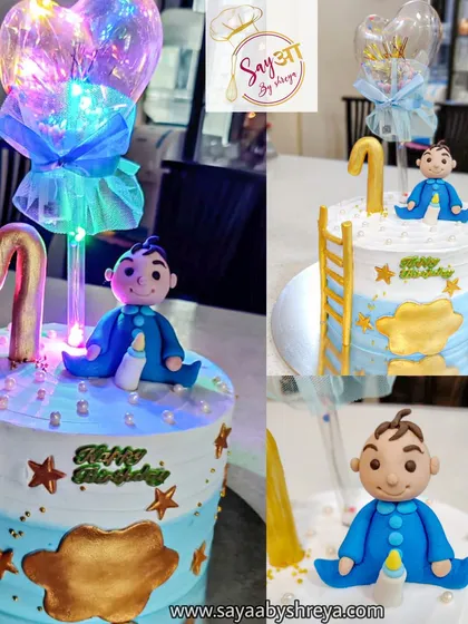 A magical cake for a baby boy's first birthday. This design includes a cute fondant baby, a ladder to the stars, and a light-up balloon topper that adds a special glow to the celebration.