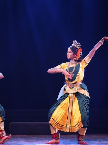 Two students in a mirror-like pose, demonstrating excellent flexibility, balance, and synchronization during their duet performance.