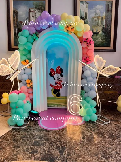 I love adding unique touches to classic themes. This Minnie Mouse setup for a 6th birthday features custom-lit butterfly props and a neon age sign, all framed by a beautiful pastel balloon arch, making it a magical photo corner.