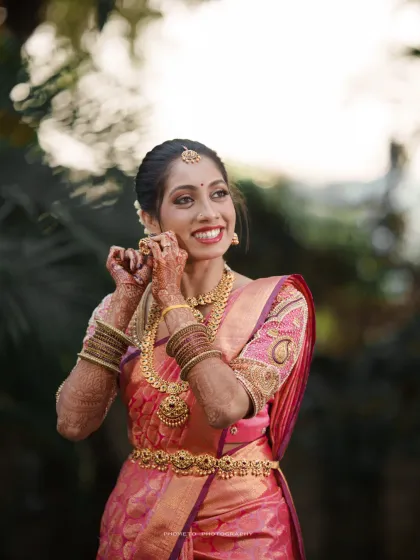 A candid moment of the bride adjusting her earring, her joyful expression perfectly captured.