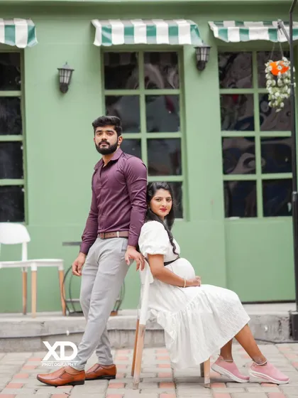 A chic and modern couple's pose against a stylish green cafe-style background.