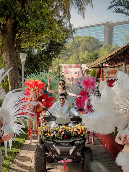 The couple makes a grand entrance on an ATV, surrounded by carnival dancers in feathered costumes. This is how we kick off a high-energy wedding carnival.