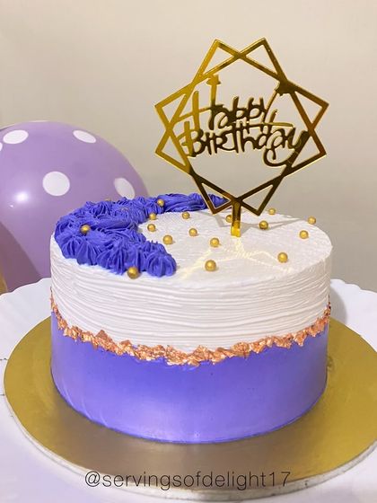 A beautiful purple and white cake with a touch of gold leaf. The flavor inside is vanilla with a blueberry compote, a delicious and popular combination.
