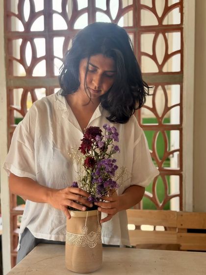 Here I am arranging flowers in a Déesse vase. The collection extends beyond drinkware to include decor pieces that bring the same narrative of strength and beauty into your living space.
