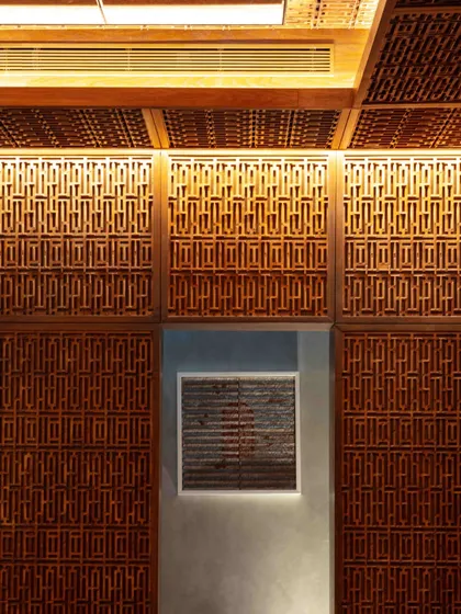 A detail of the Pinjirakari-inspired lattice work on the ceiling and walls of the Bammi Residence dining room. This traditional woodcraft creates an intricate, jewel-box effect, filtering light beautifully.