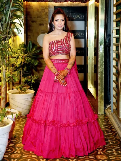 A full-length portrait of the bride in her vibrant pink Mehndi outfit, looking elegant and ready to celebrate.