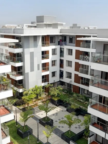 An aerial perspective of the Sona Vistaas residential cluster in Bengaluru, where buildings are organized around a central, verdant courtyard. This layout is a core principle of my township planning, designed to enhance microclimates and create a shared sense of place.