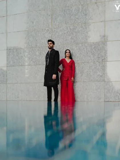 A modern, editorial-style portrait of a couple standing by a pool, their figures reflected in the water against a sleek, architectural backdrop. This demonstrates our ability to create high-fashion engagement portraits.