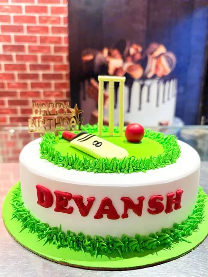 A classic cricket-themed cake with a pitch, bat, ball, and wickets, perfect for any cricket fan.