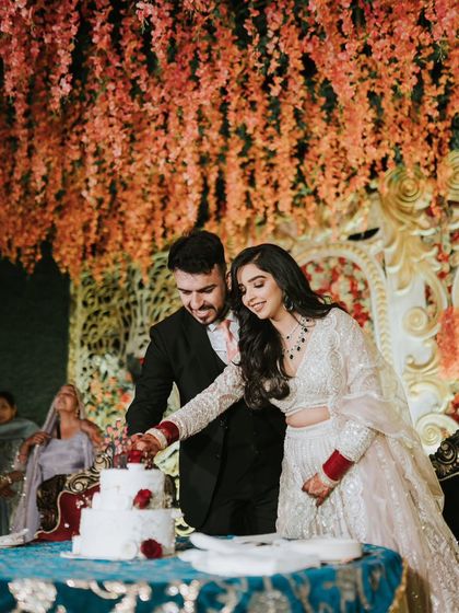 The cake-cutting moment. Her makeup is bold enough to stand out in the festive reception lighting but still looks elegant up close.