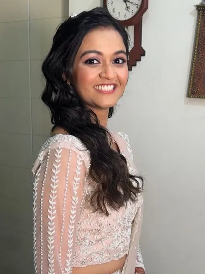A side profile showing the soft waves and the subtle glow of her makeup. Effortlessly beautiful.