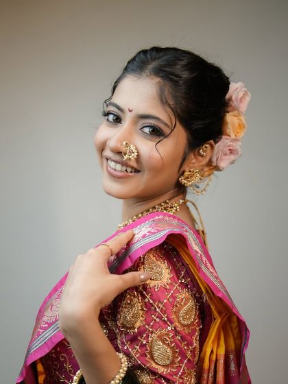 A beautiful profile shot showing the soft makeup and the lovely floral hair accessory. This is a perfect example of traditional elegance.