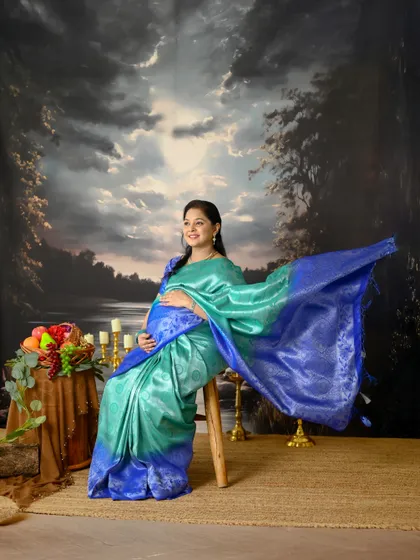 A saree brings such timeless elegance to a maternity shoot. This portrait, set against a classic painted backdrop, has the feel of a beautiful, old painting.