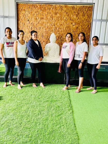 A group of our members posing with the Buddha statue after a calming yoga session.