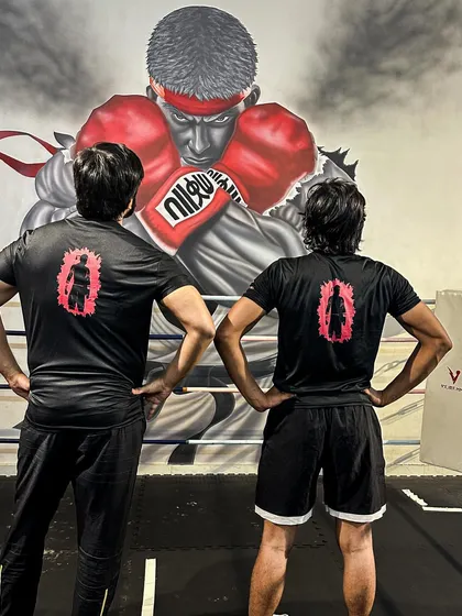Standing with a student in front of our gym's mural. We are all warriors on our own journey.