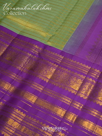 The rich purple pallu with its bands of gold zari provides a stunning contrast to the light green body.