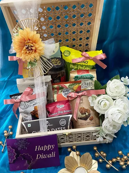 We believe in making festivals memorable. This Diwali hamper, set in a beautiful cane and wood box, is filled with gourmet snacks and treats, all elegantly wrapped and ready to delight your loved ones.