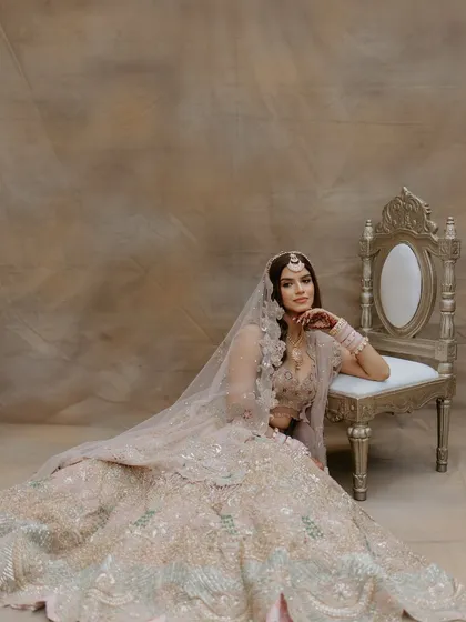 A full-length view of the beautiful pastel lehenga. The soft makeup ensures the focus remains on the bride's natural beauty and her exquisite attire.