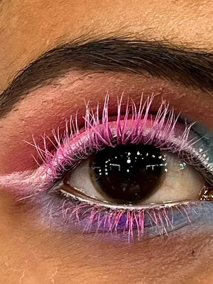 A macro shot of a creative eye makeup concept. I used custom-colored pink lashes and a soft blend of pastel eyeshadows with a sharp white wing to create a playful and artistic look.