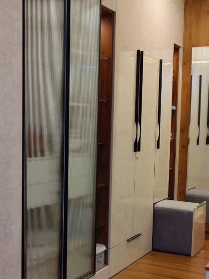 This wardrobe holds a clever secret. I designed it with a hidden, tucked-in pouf that can be pulled out for a comfortable seat at the vanity, making it a perfect example of smart, space-saving design.