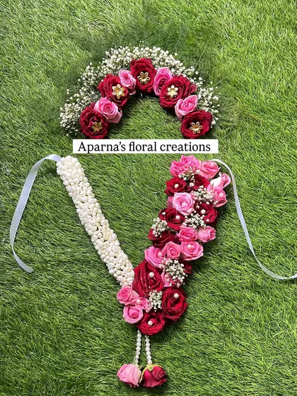 A beautiful Kanthi (necklace) and Veni (hair accessory) set made with red and pink roses, baby's breath, and pearls. This is perfect for a bride or for a festival.