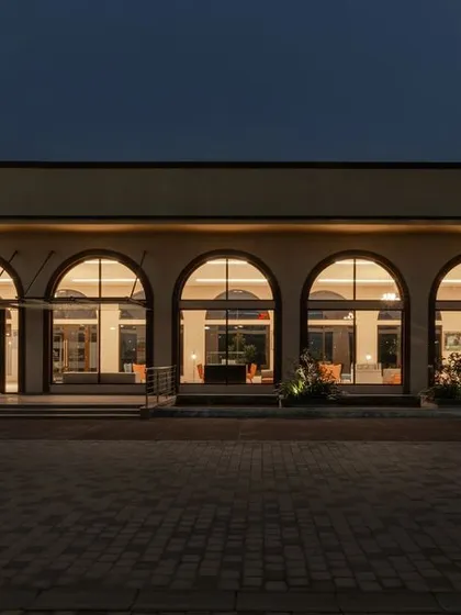We designed the Brigade Valencia marketing office to be a welcoming space, inspired by the palaces of southern Spain. The series of arches glows with warm light at dusk, creating an inviting facade that moves beyond the typical cold corporate office.