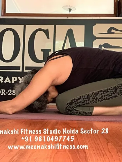 A side view of Child's Pose, a gentle stretch for the back, hips, and thighs.
