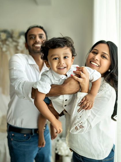 Moments with the sunny boy. This happy family portrait is full of bright smiles and positive energy.
