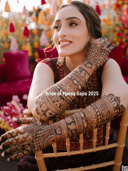 Bridal beauty in its purest form. A radiant bride shows off her freshly applied mehendi, her smile and the intricate details creating a look of effortless elegance.