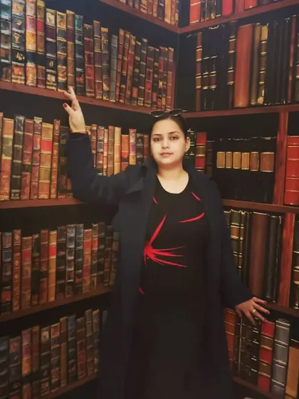 Standing confidently in a room full of law books. This setting is my second home, where I arm myself with the knowledge needed to fight for you.