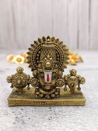 A frontal view of the brass Tirupati Balaji face idol, highlighting the detailed craftsmanship and the divine expression.