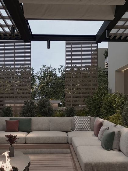 Another angle of the outdoor lounge, showing the slatted wooden screens that provide privacy and add a textural element. The deep, comfortable cushions invite long, relaxing evenings outdoors.