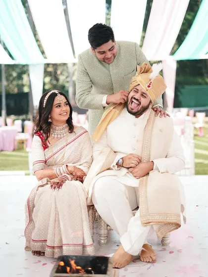 A playful moment during the ceremony where a brother teases the groom. This image captures the fun, lighthearted family dynamics that make a wedding special.