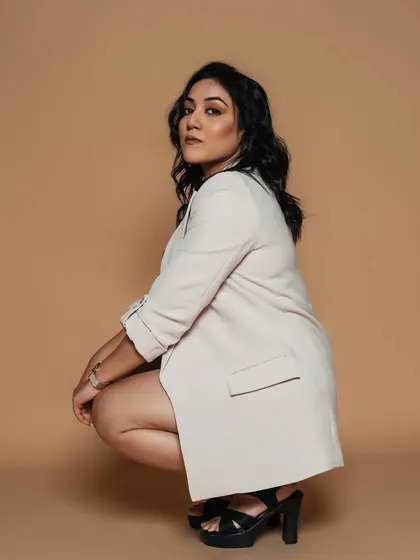 A dynamic pose in a modern blazer. The makeup is versatile enough to work for both a professional look and a more fashion-forward, edgy vibe.