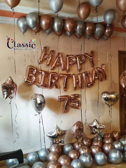 A simple yet classic room decoration for a 75th birthday. We use rose gold 'Happy Birthday' foil letters, matching number balloons, and a mix of chrome and metallic balloons on the floor and ceiling.